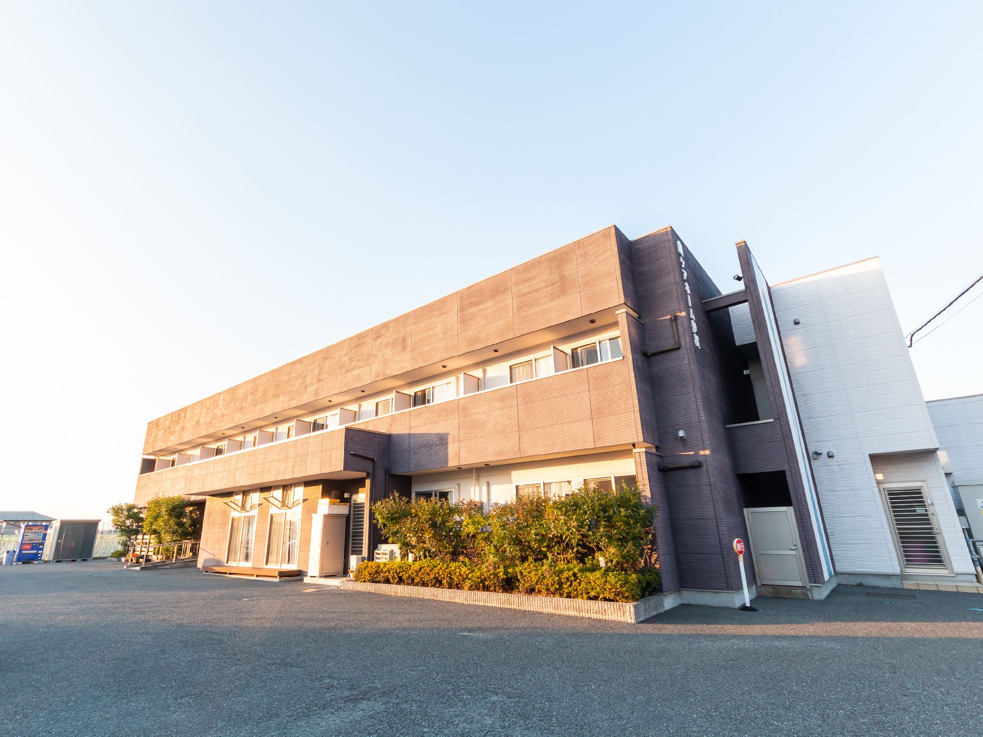 2階建てで、茶色の落ち着いた色合いが特徴の施設の外観