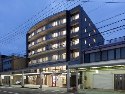 アーケードがある商店街の中に位置している建物である。ベランダがあり、窓からは部屋の明かりがみえている。