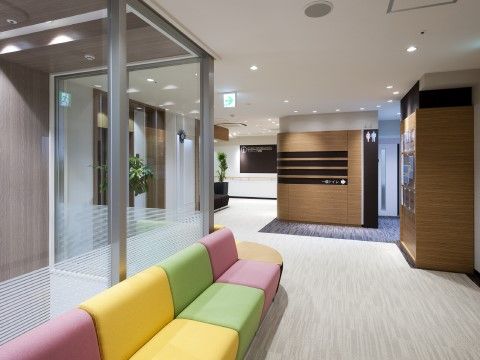 緑やピンク、黄色のカラフルなソファが置かれた通路。段差もなくフラットな床は車椅子をご利用の方や足の不自由な方も安心して通ることができる。