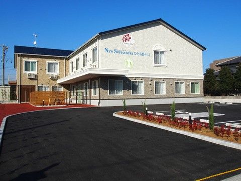 綺麗な花と木で整えられた駐車場と、一軒家のような2階建ての施設