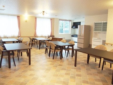 食堂の一角には入居者様も利用できる小型のキッチンがある。壁際には大型の冷蔵庫と食器棚が置かれている。