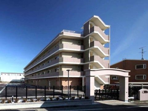 大きな門をくぐったところに建つ、駐車場を完備した4階建てのマンション型施設