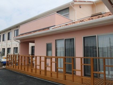アパート型のグループホームと、木製のおしゃれな柵が付けられた別館