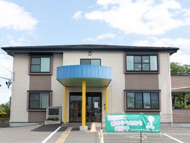 駐車場が整備され、民家のような外観が特徴である施設の外観