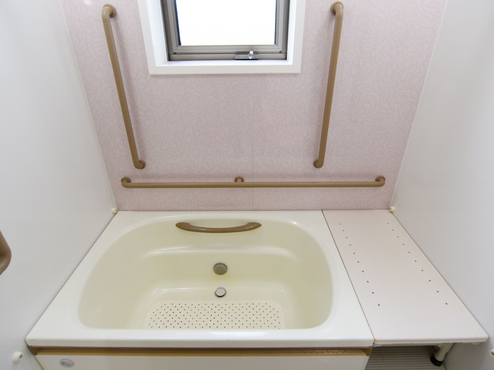 一人がゆっくりと湯船につかれる広さの浴槽である。横側に窓があり、壁には、縦横の手すりを完備している。浴槽の中にも手すりがある。