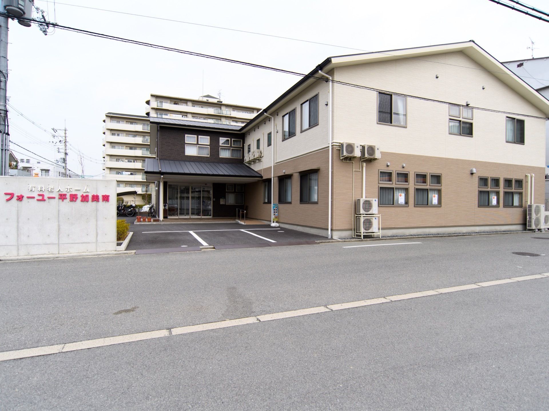 ツートンカラーの外壁に三角屋根の棟と、焦げ茶色の外観の玄関棟がエル型になった建物である。敷地内には、車を停められるスペースを設けている。