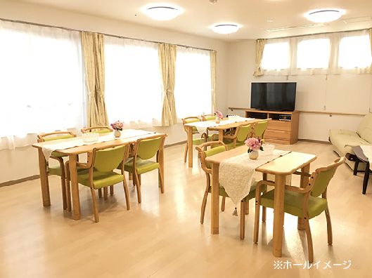 レースカーテンとカーテンが付いた窓がある食堂にはライトグリーンの椅子がセットされた木製のテーブルセットが置かれている。