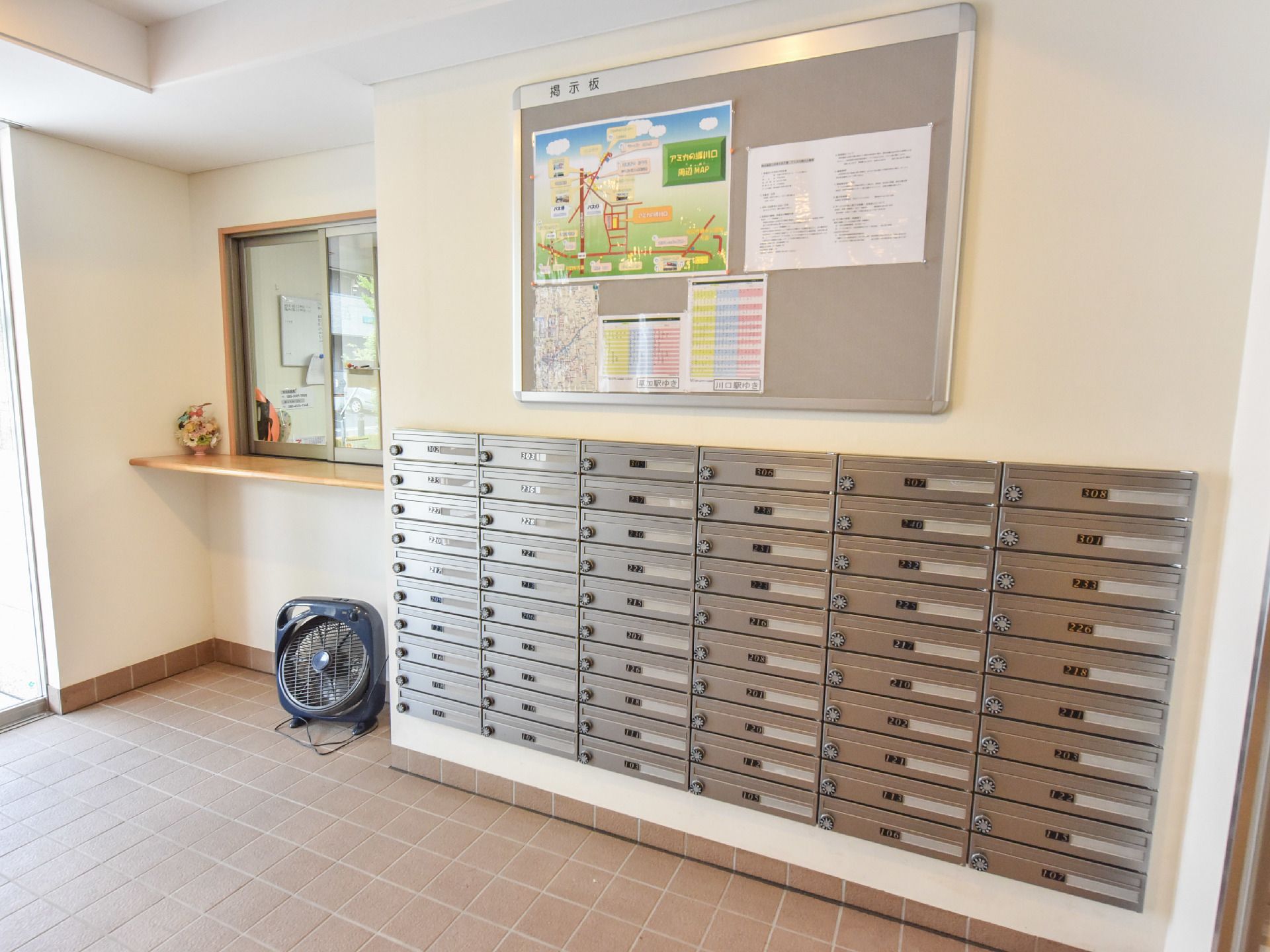 受付の横は各入居者用の郵便ポストが設置されている。また、壁上部には連絡事項などを確認できる掲示板が設置されている。