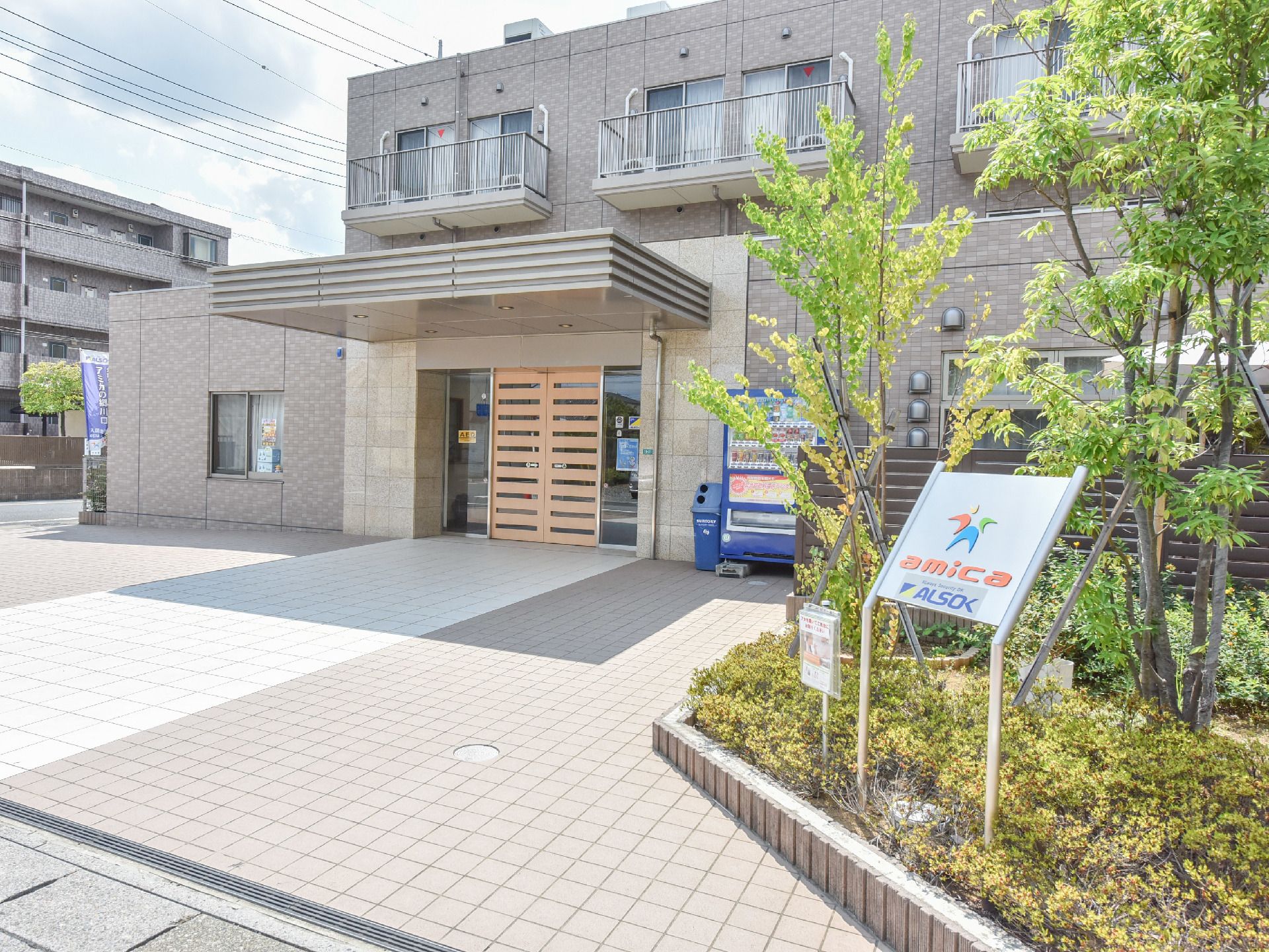 レンガ調の外壁に木の自動ドアが特徴的な住宅街の中の施設