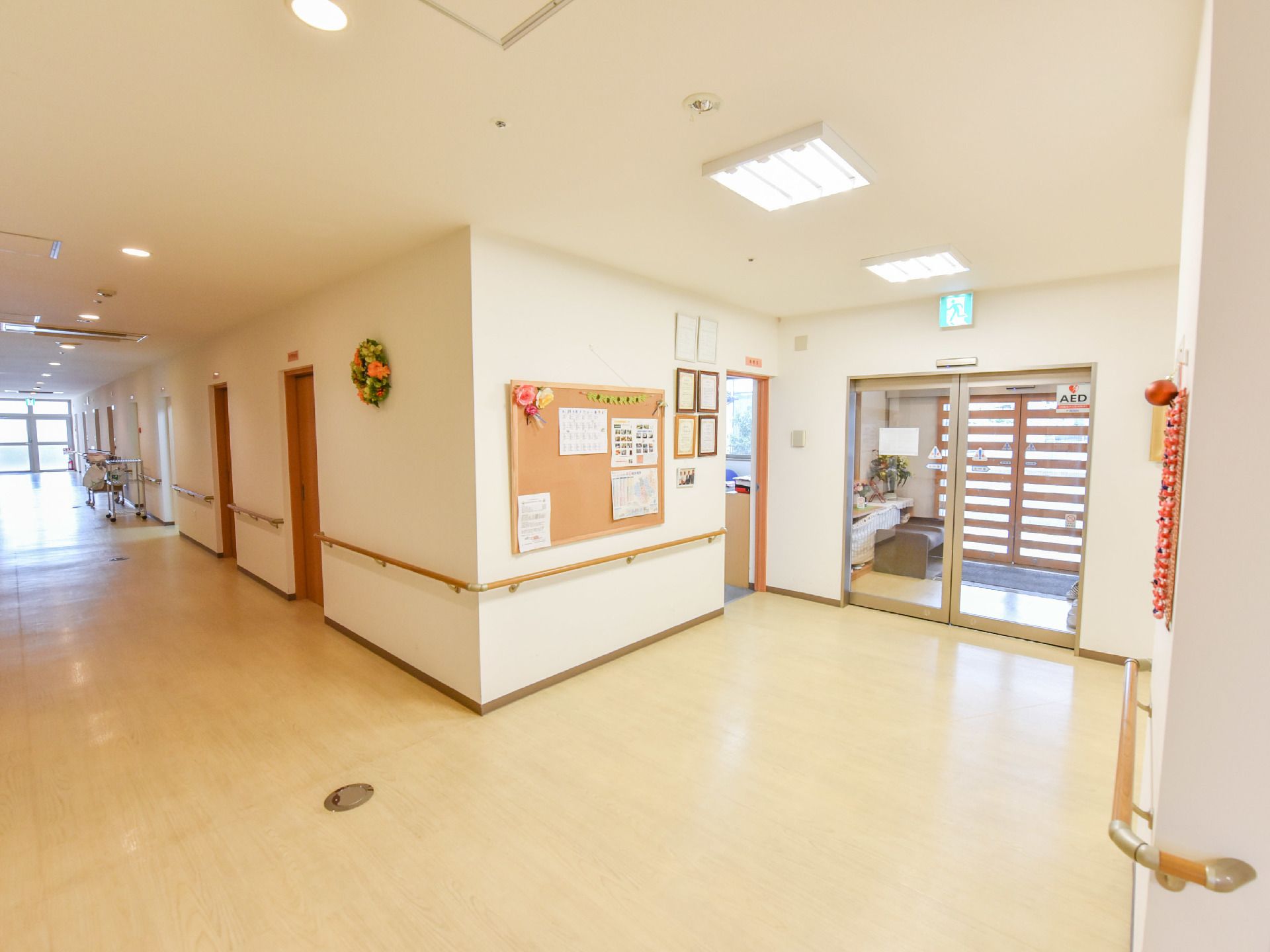廊下は広々としており、突き当たりからは光が漏れている。入り口は両開きでガラス製の自動ドアになっている。