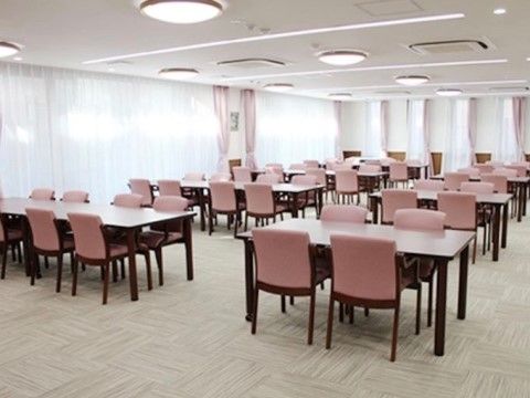 白とピンクで色調が統一されている食堂。4人が座ることができるダイニングテーブルが準備されている。広い空間で大勢の入居者様が集うことができる。