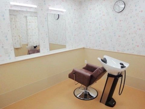 理容椅子とシャワー台が部屋の中央にあり、個別で髪を切ってもらえるようになっている。部屋全体がゆったりとした余裕のあるスペースになっている。