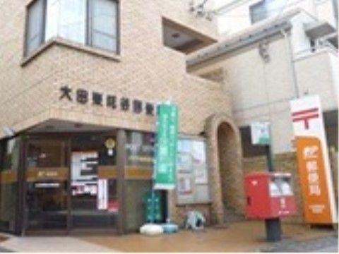 淡い茶系の外観で、正面の入口は自動ドアになっている。郵便局を出てすぐ前に郵便ポストがある。緑色ののぼりが立っている。
