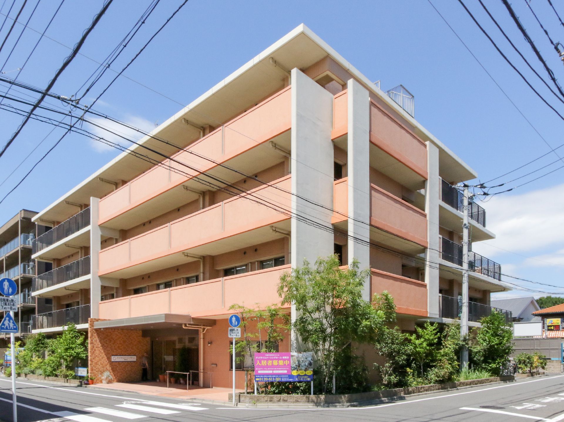 アスファルトに隣接しているオレンジの外観で４階建ての建物