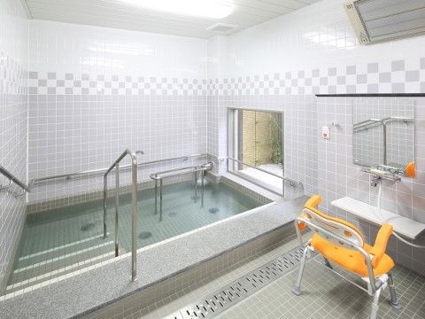 明るい浴室の右奥には透明ガラスのフィックス窓が設置されており、入居者様は庭を眺めながら入浴することができる。