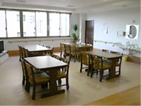 4人掛けテーブルが複数置かれた、鏡付きの洗面台がある部屋