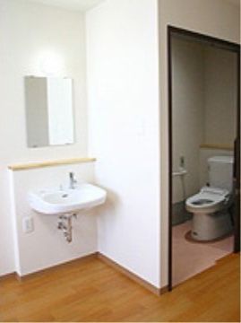 横開きドアのトイレの外に設置された、鏡付きの洗面台