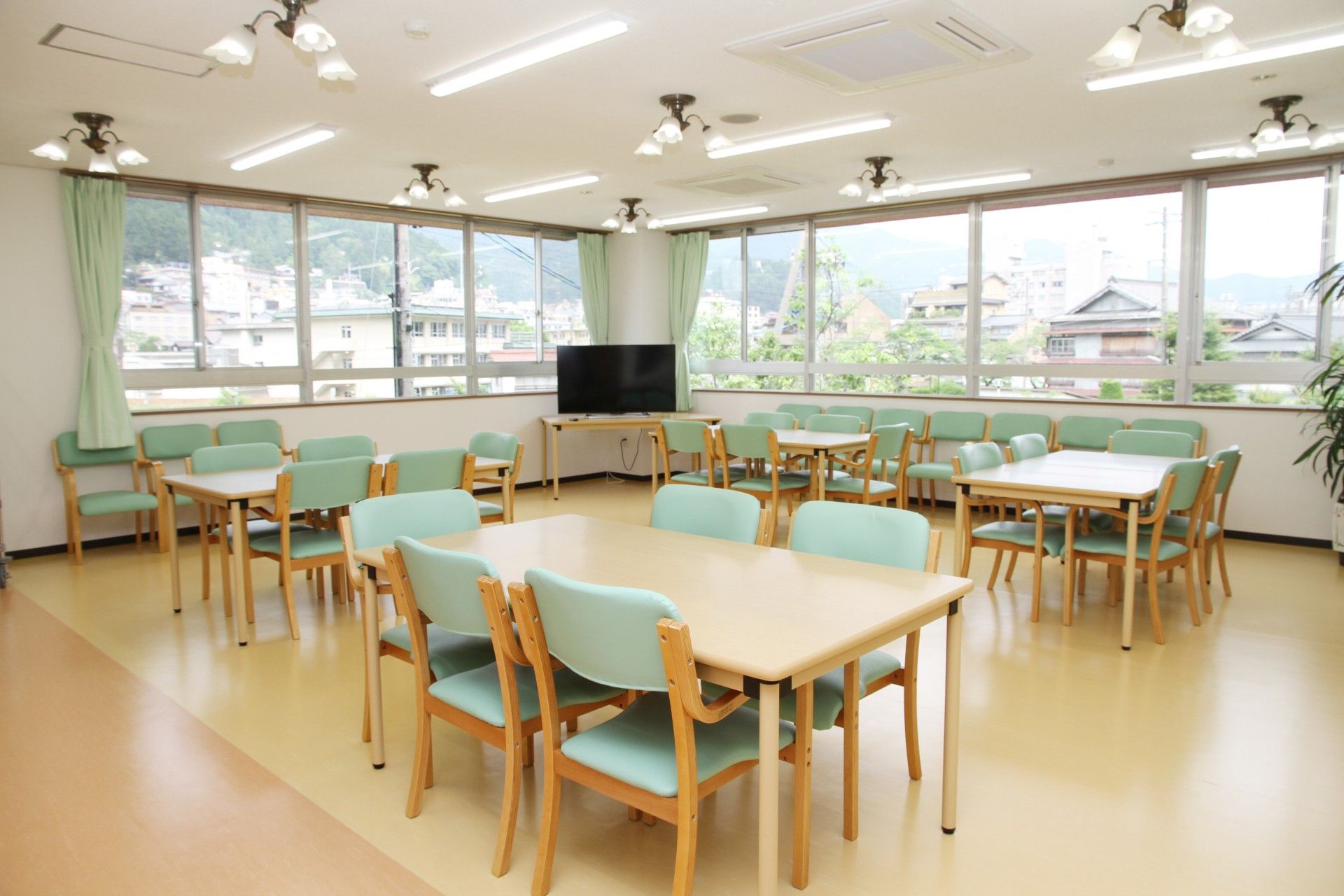 広々とした空間の中に、それぞれに椅子が並べられた長方形のテーブルが複数台設置されている。スペースの一角にはテレビが用意されている。