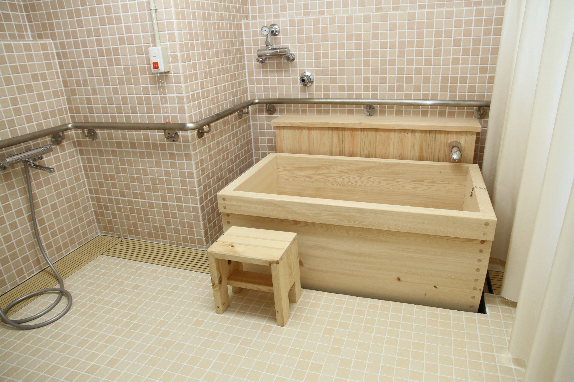 木の素材をふんだんに使用したコンパクトな大きさの浴槽が整えられている。また、安全に入浴するための踏み台が併せて用意されている。