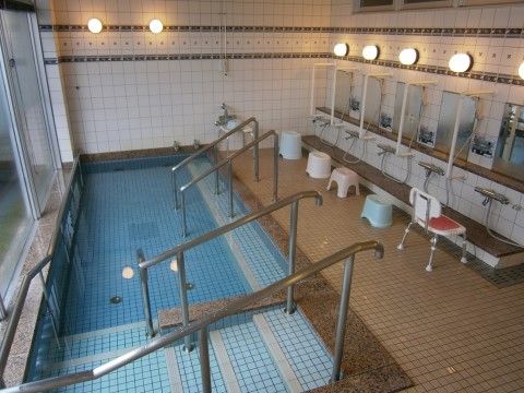 大人数で使用することができる浴室。大きな浴槽をはじめ、シャワーの横には手すりが備え付けられ、シャワーの前にはシャワーベンチが置かれている。