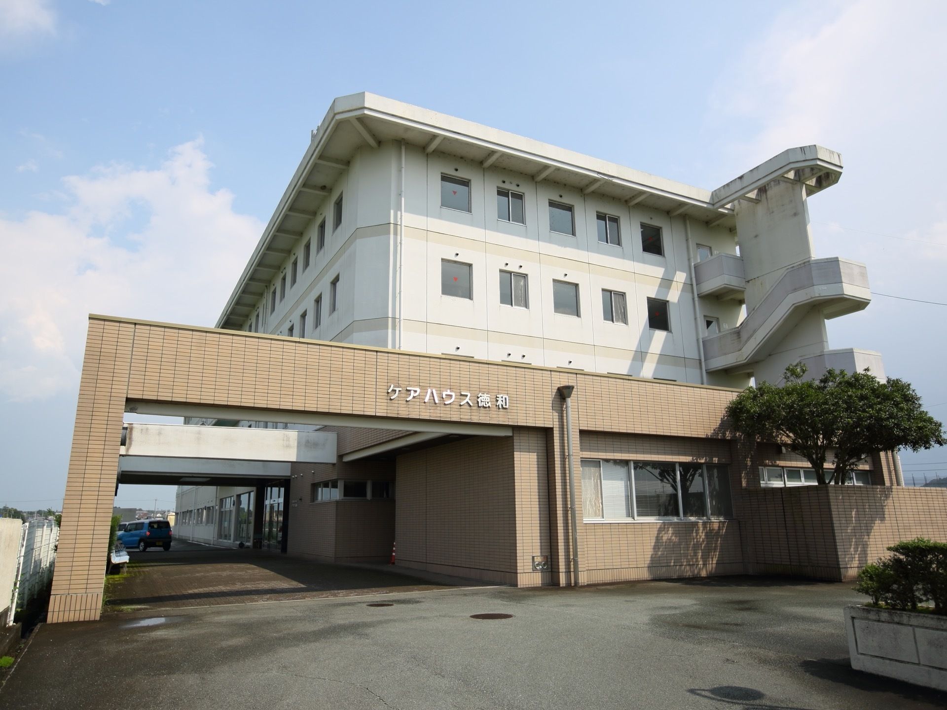 ベージュ色が基調となった４階建ての建物である。外階段が設置されており、非常時に上階から直接避難できる経路が確保されている。