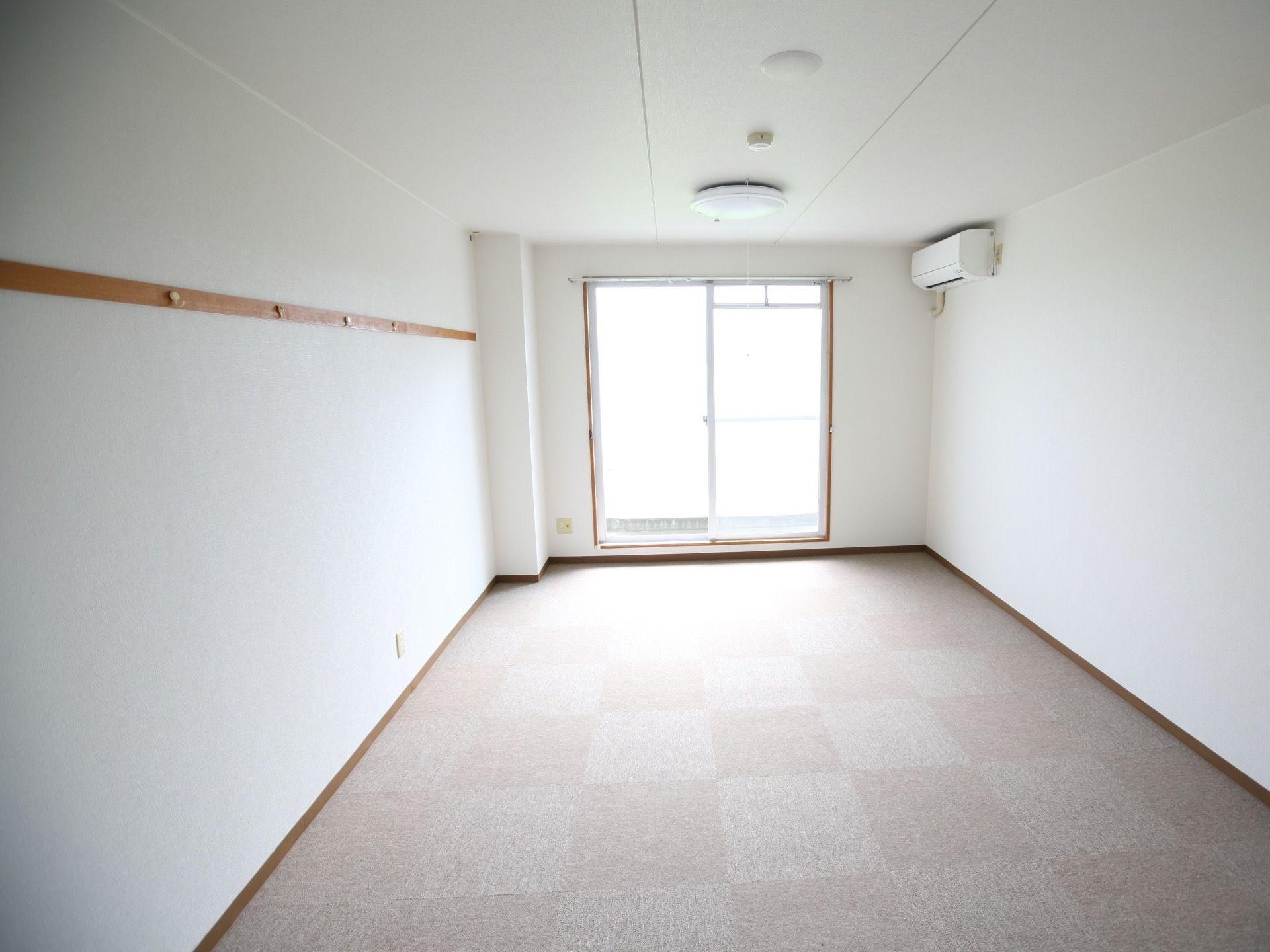 真っ白な天井と壁で清潔感のある居室。エアコンが設置されており、どの季節も室内を適温に保つことができる。