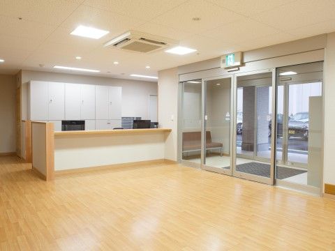 入口がガラスの自動ドアになった、フロントのある広いエントランス