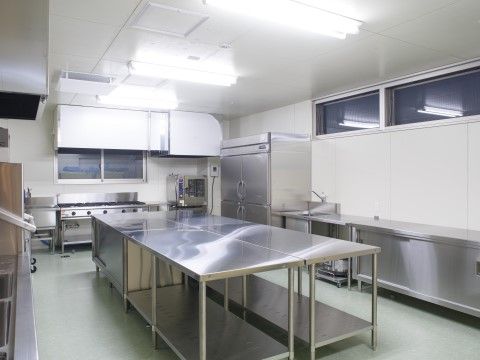 大きなコンロと業務用の冷蔵庫がある広々としたキッチン