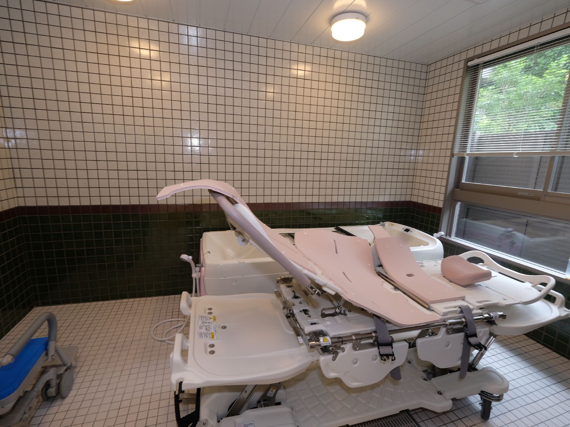 大きな窓から光が差し込む広々とした介護浴室。介護度の高い方や寝たきりの方の入浴ができる機会浴槽が設置されている。