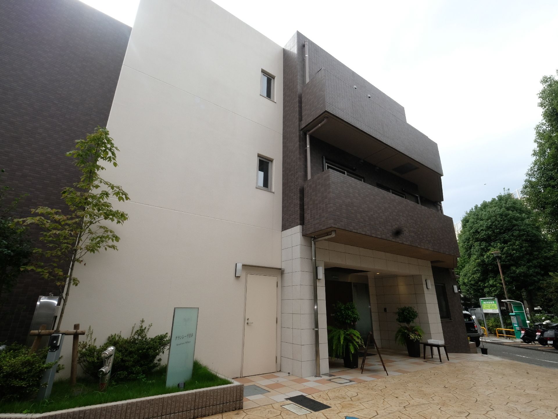 緑の多い環境に立地している3階建てのスタイリッシュな外観。外壁はブラウンと白を基調としており、都会的な雰囲気がある。