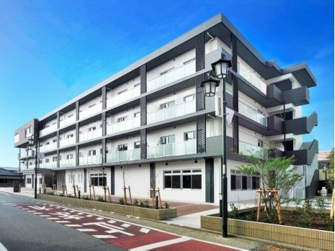 外階段で各階が繋がっている、道路に面した4階建ての建物外観