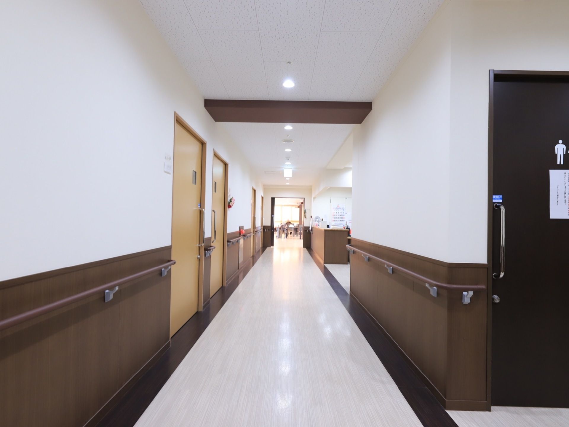 壁に手すりが備え付けられた内廊下が伸びている。居室やトイレの入口が並んでおり、ドアは引き戸が使われている。