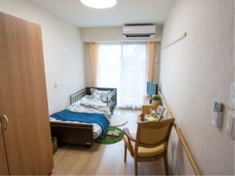落下防止柵付きのベッドとテレビが置かれた、エアコン付きの部屋
