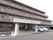 ブラウンを基調とした落ち着いた雰囲気の4階建ての施設の外観。建物の前には駐車スペースが完備している。