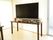 茶色いテーブルをテレビ台として利用している。テレビが乗せられたテレビ台にはこまごまとした雑貨が飾られている。
