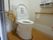 洋式トイレがある。トイレの便器の両サイドには木の手すりが取り付けられていて、用をたす際の手助けとなる。