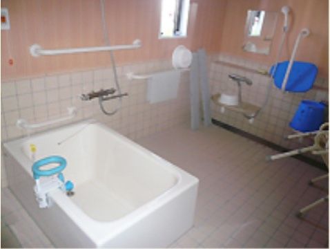 白木とタイルを基調とした浴室である。洗い場の横に小さめの窓を設けている。浴槽には、介助が必要な方の設備も整えている。
