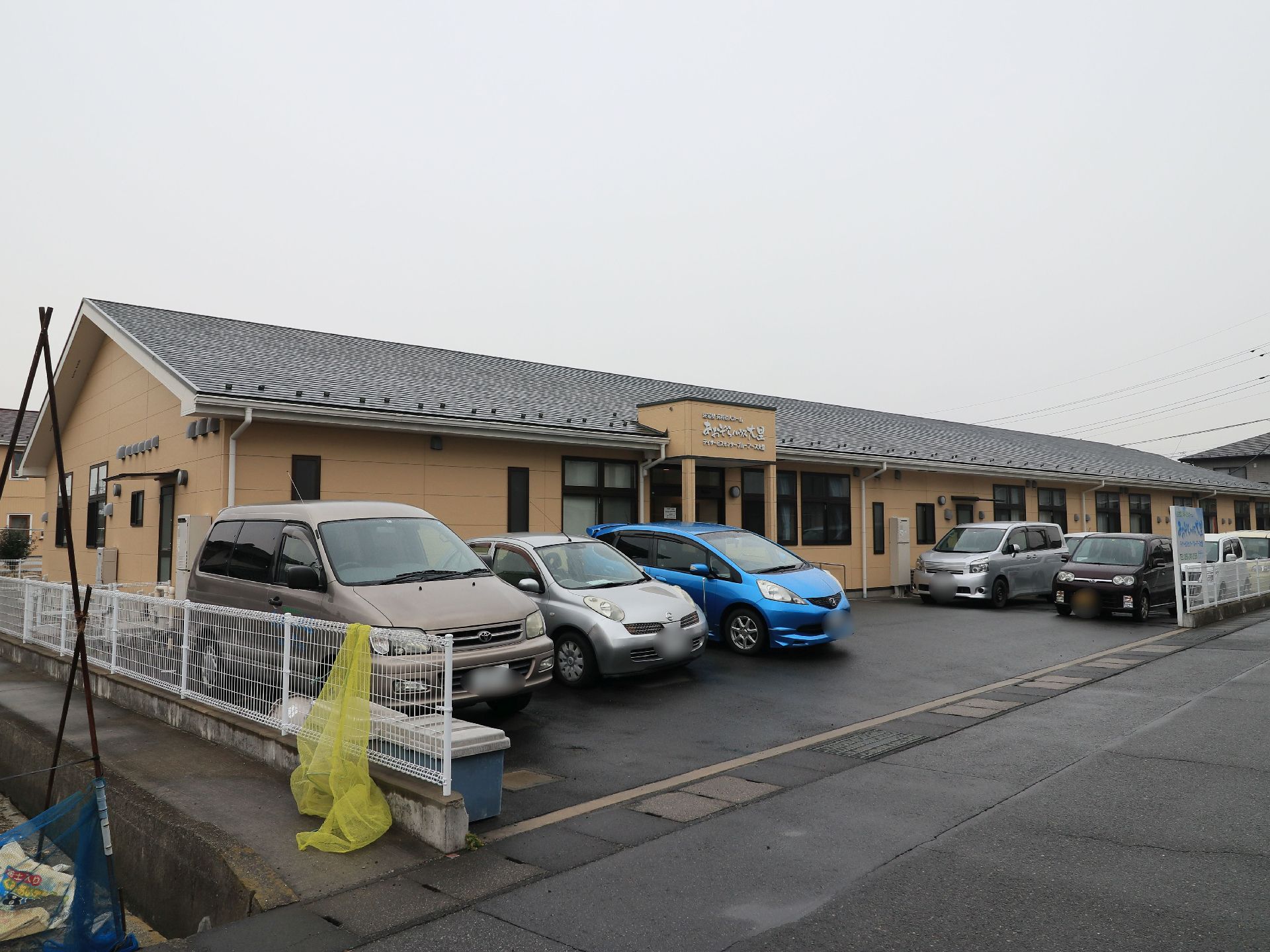 茶色を基調とした外壁の平屋建ての施設である。敷地はフェンスで囲まれていて、その中には多くの駐車スペースがある。