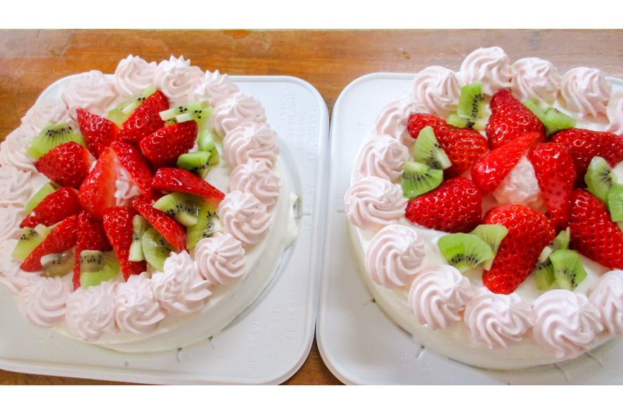キウイフルーツと苺がトッピングされた2個のホールケーキ
