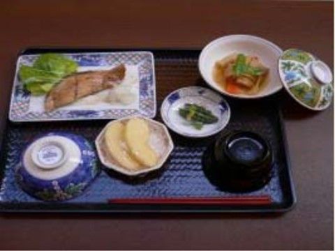 焼魚と煮物にデザートのリンゴが付いたある日の食事メニュー