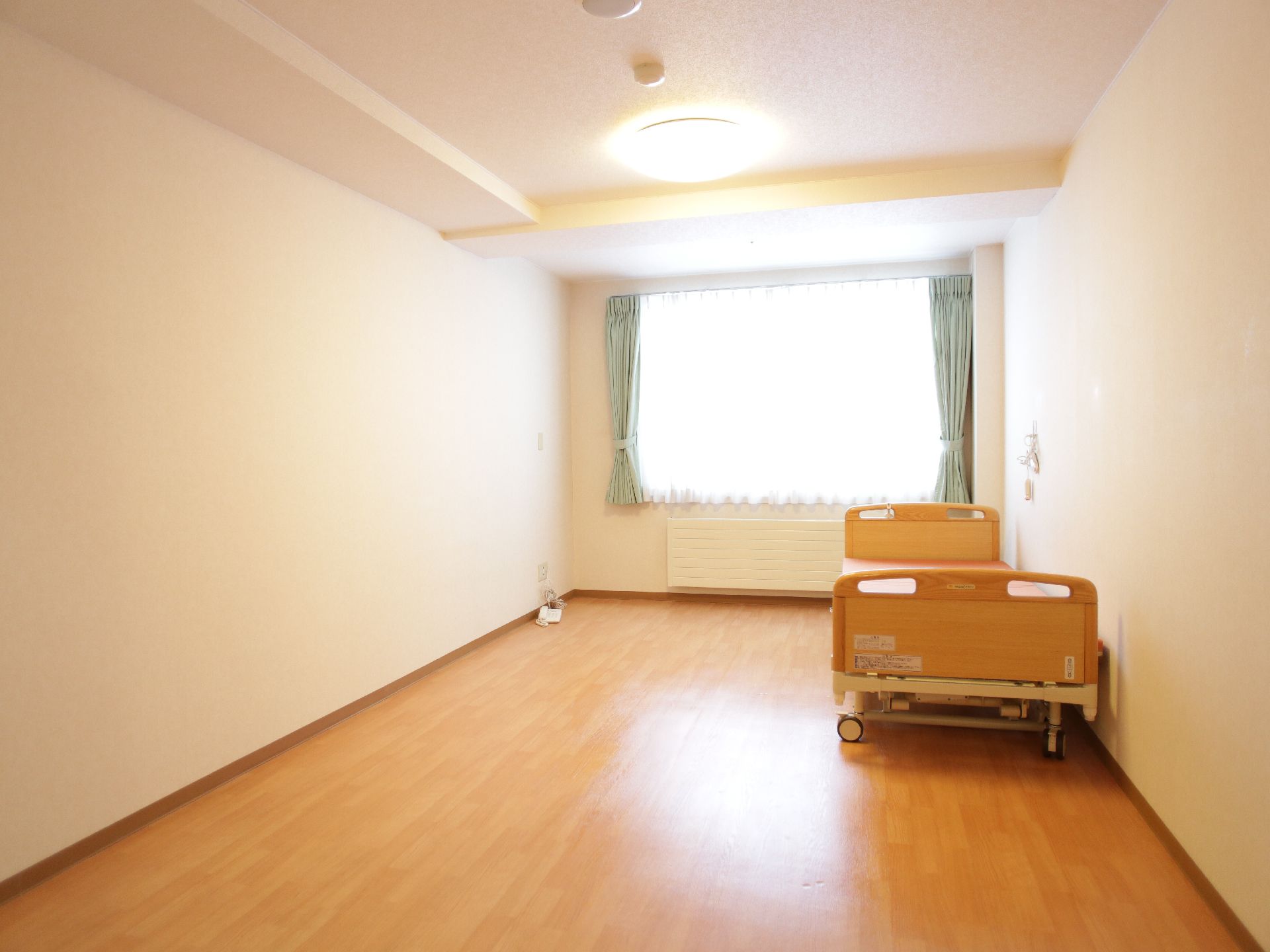 落ち着いた色合いでまとめられている居室はすべて個室タイプ。万が一の場合に呼び出しボタンが設置済されている。