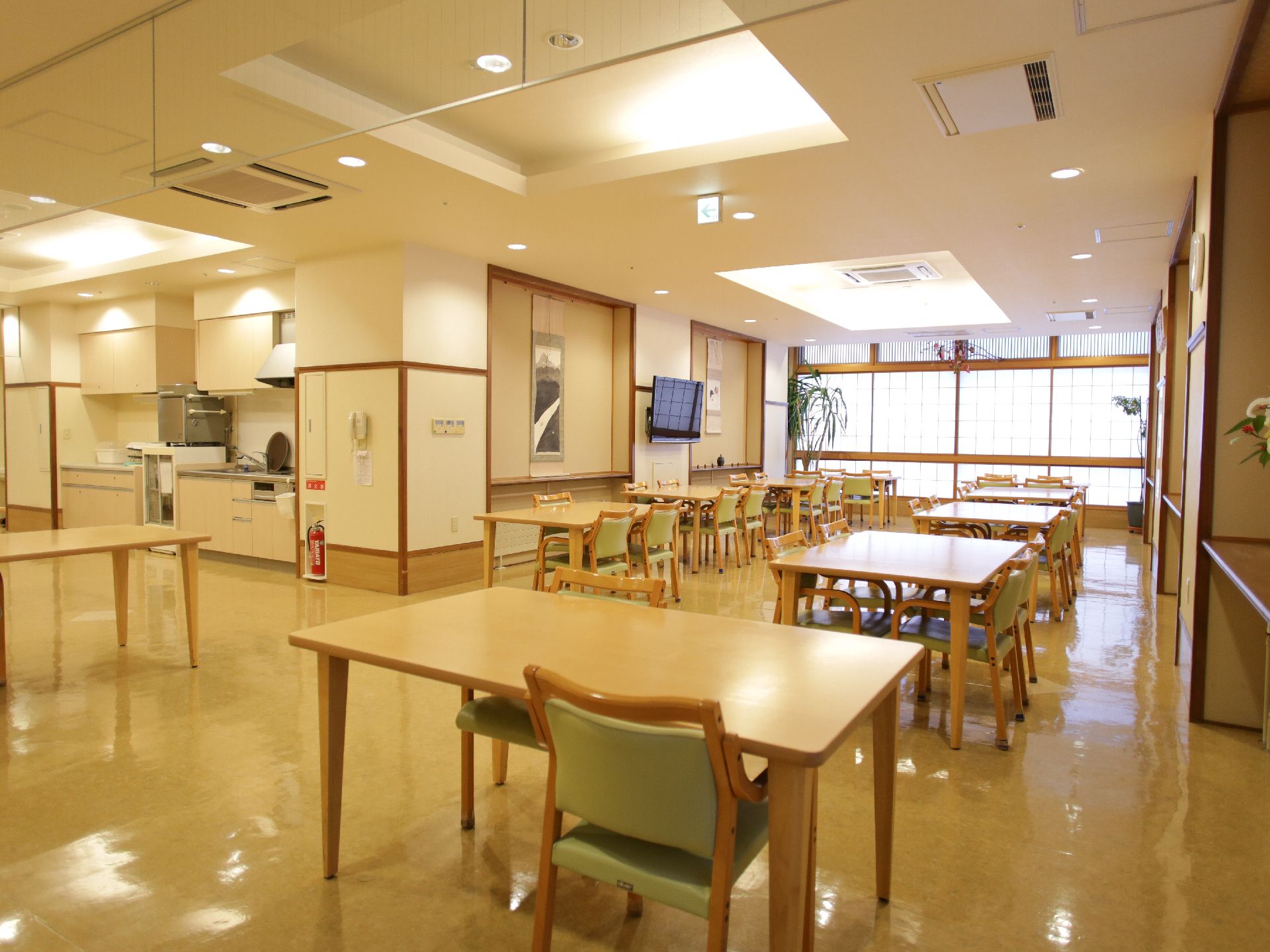 新館の食堂には、4人掛けのテーブルと椅子があります。食堂内のパントリーにはコップや飲み物が置いてあります。