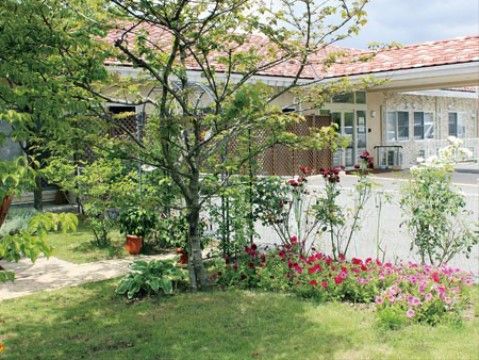 色とりどりの花と木で整えられたグループホームの外の庭