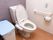 温水洗浄便座の付いた洋式トイレである。便器の横の壁には、手すりや緊急時呼び出しブザーが備わっている。