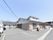 三角屋根の平屋造りの建物で、施設内に駐車スペースが整備されている。各居室の窓の外には、エアコンの室外機が設置されている。