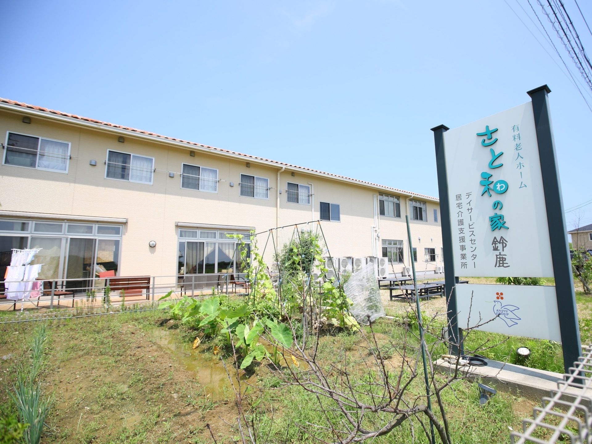 施設の入り口には、施設名の入った大きな看板を設置している。周りには多くの緑があり、自然に触れながら過ごすことができる。