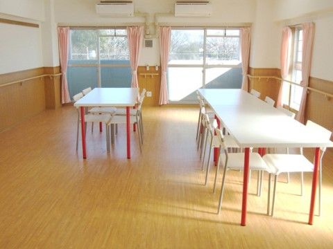 アートプラザ田能300のリビング。白いテーブルにピンクの足が映えるダイニングテーブルを使用。