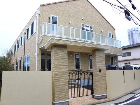自宅のようなイメージの外観で、住宅街に馴染みながら佇んでいる。デザイン性の高い門を構え、両側には塀を設けている。