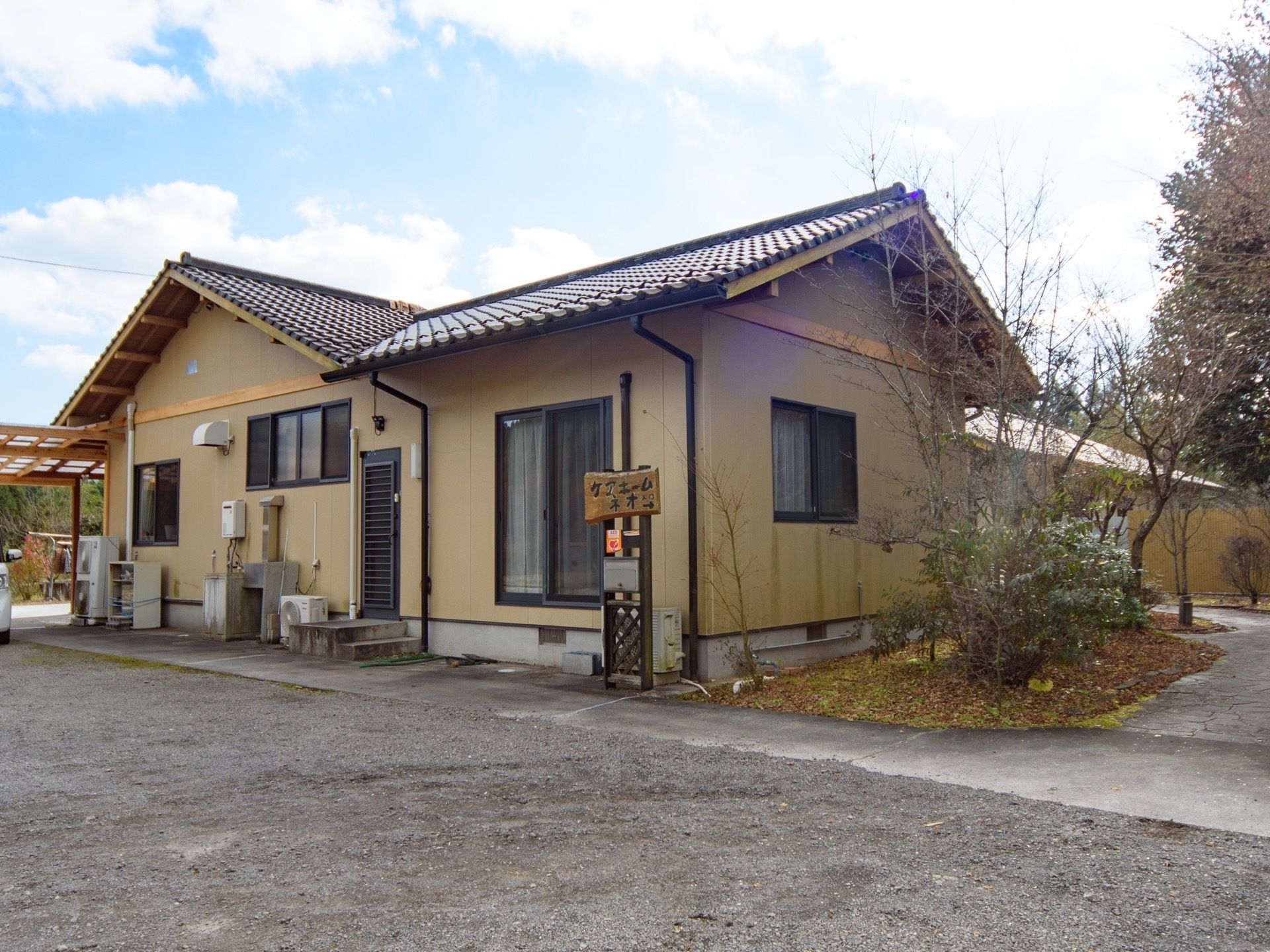 自然に恵まれた落ち着いた環境にあり、建物の周りは平らで開放的なため、ゆっくり自然を見渡すことができる。平屋で落ち着いた色調の和風建物。