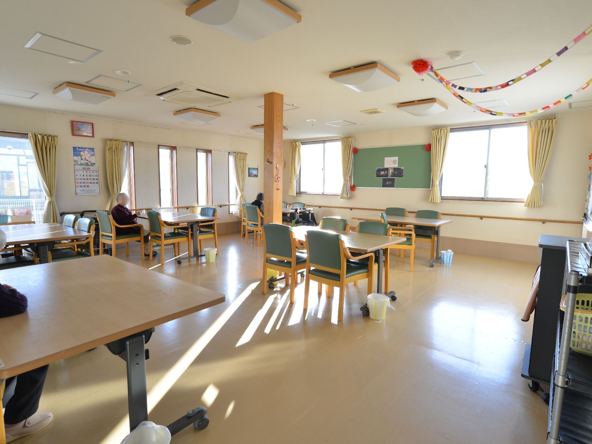 窓も大きく広々とした開放的な空間。食事をしたり、のんびり過ごしたりでき他の入居者の方ともコミュニケーションが取れる多目的スペース。